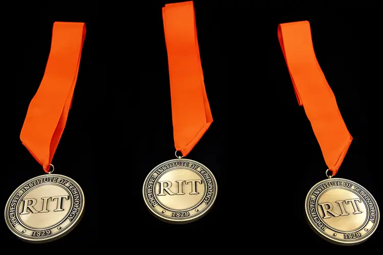 a series of 3 medals with orange ribbons are shown on a black background