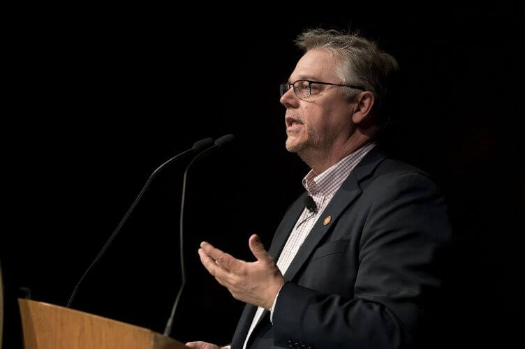 William Snyder speaking at a podium.