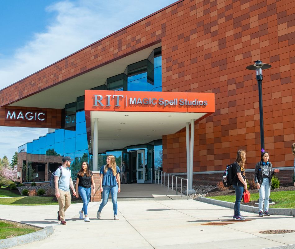 Two students standing outside the entrance to a brick building