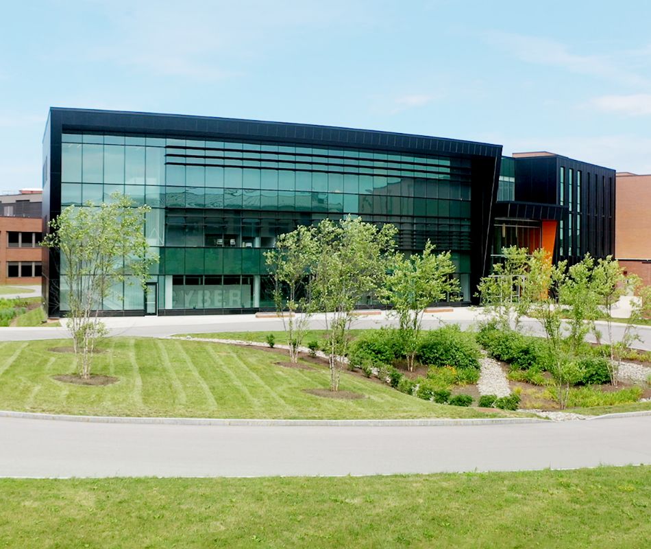 Green grass in front of a building with a glass exterior
