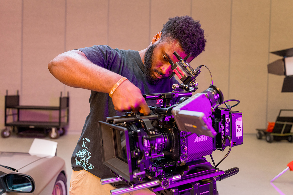 A student operates a film camera on MAGIC Spell Studios' soundstage.