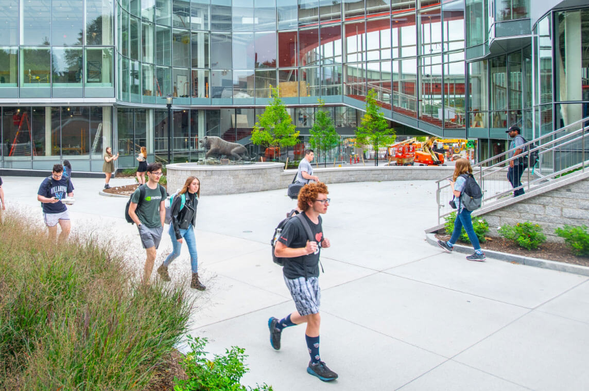 Students walking in the natural spaces around the SHED, during the day.
