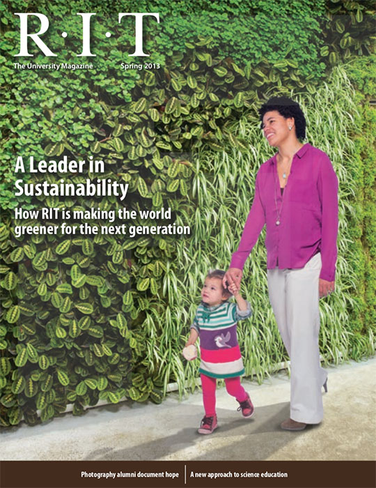 Woman walking with her daughter along a green wall
