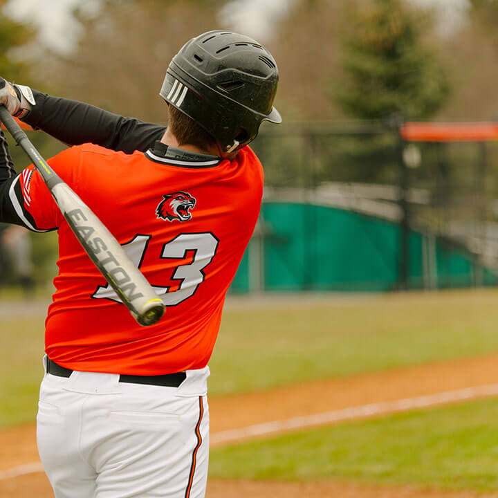 R I T baseball player swinging a bat