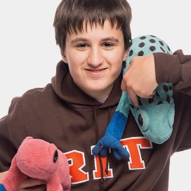 Photo of Adam holding 2 stuffed animals.