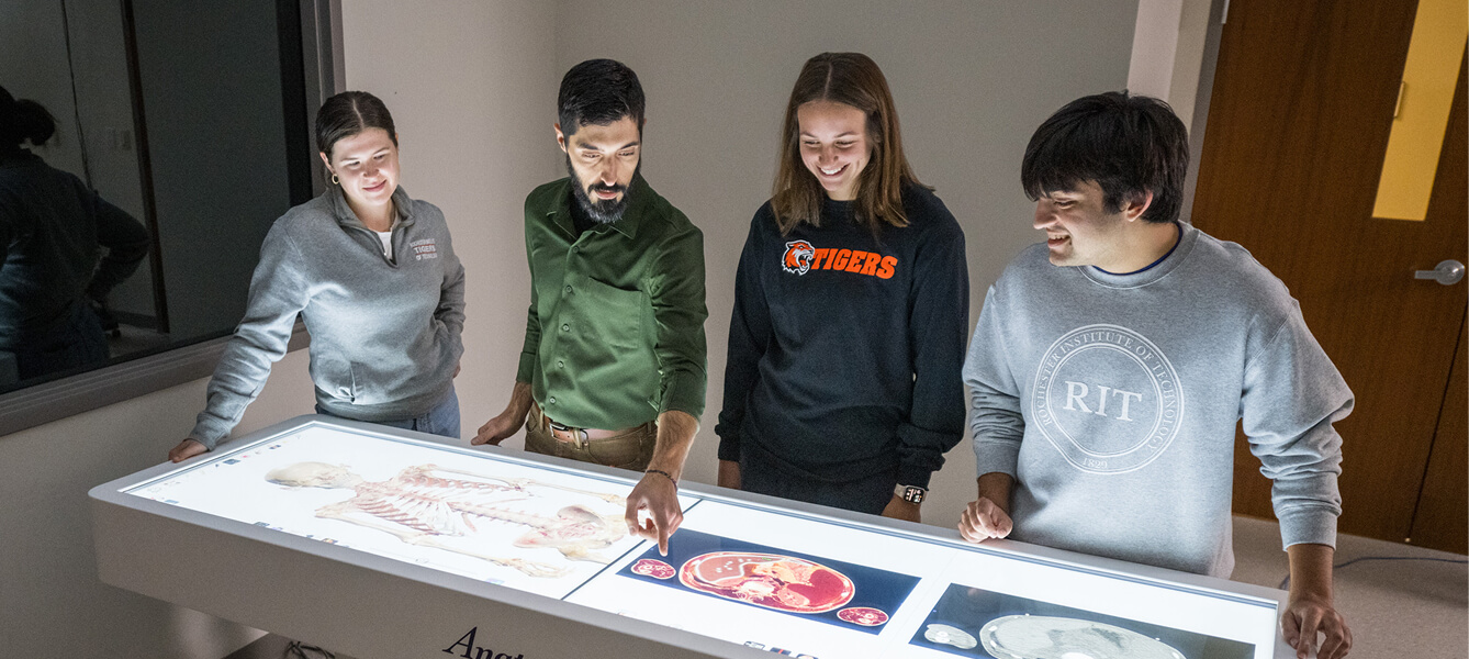 Four people standing around the anatomy table.