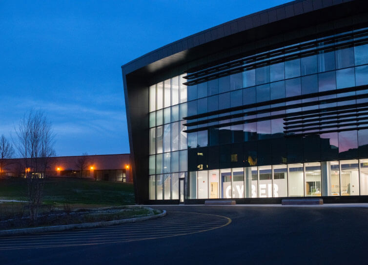 Exterior of the ESL Global Cybersecurity Institute in the evening.