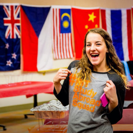 Student posing in front of flags