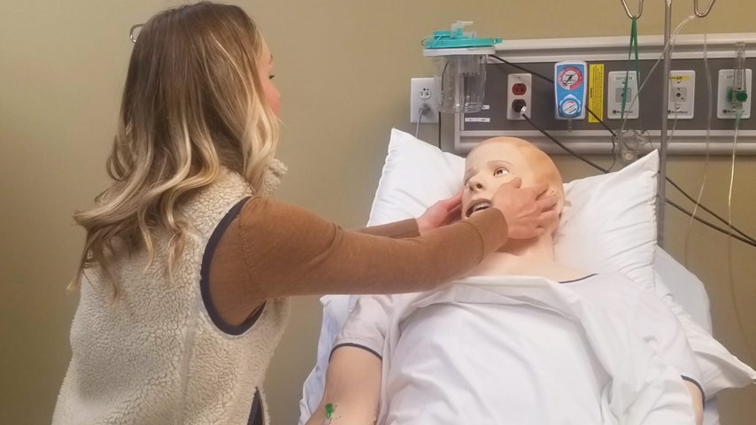 A student works with the simulation mannequin.