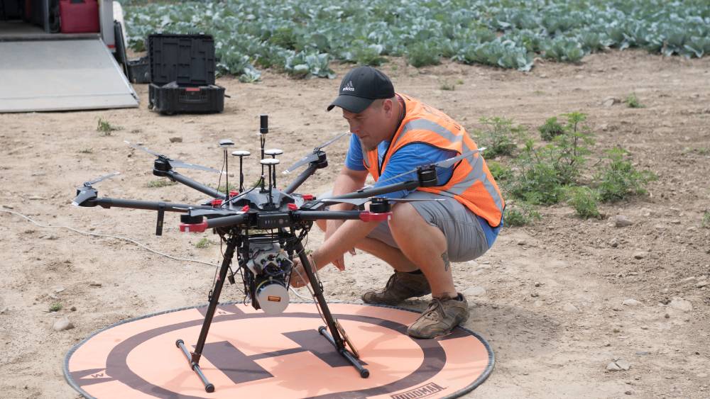 Engineer setting up drone on a ground landing pad