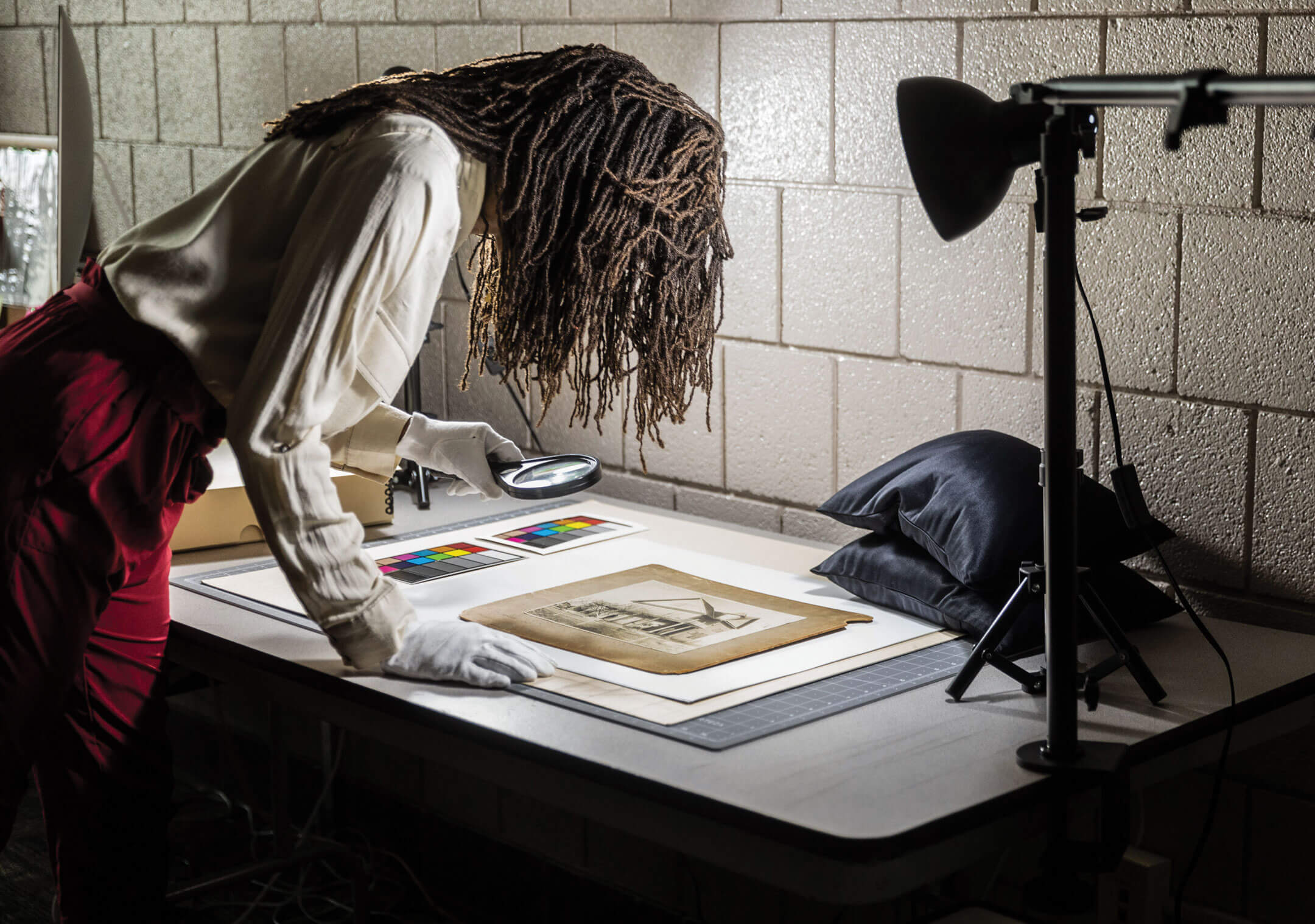 Kayla Jackson inspecting an old photograph of a house.