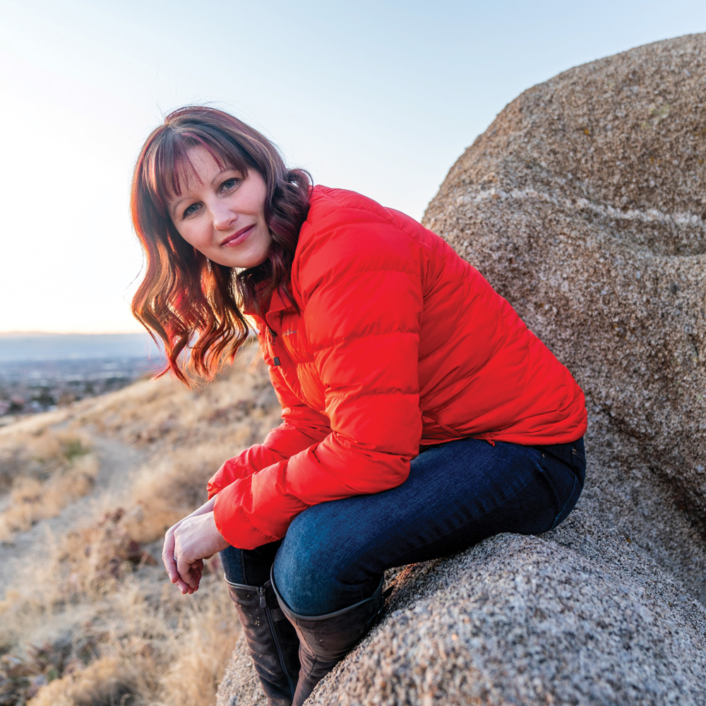 Woman sitting on a rock wearing a red coat