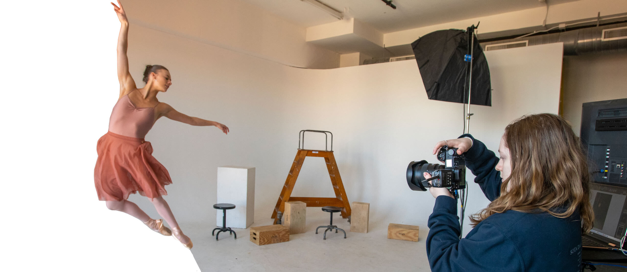 MacKenna Rhoads, dressed in an outfit for a dance recital, leaps in the air while a photographer takes her picture.