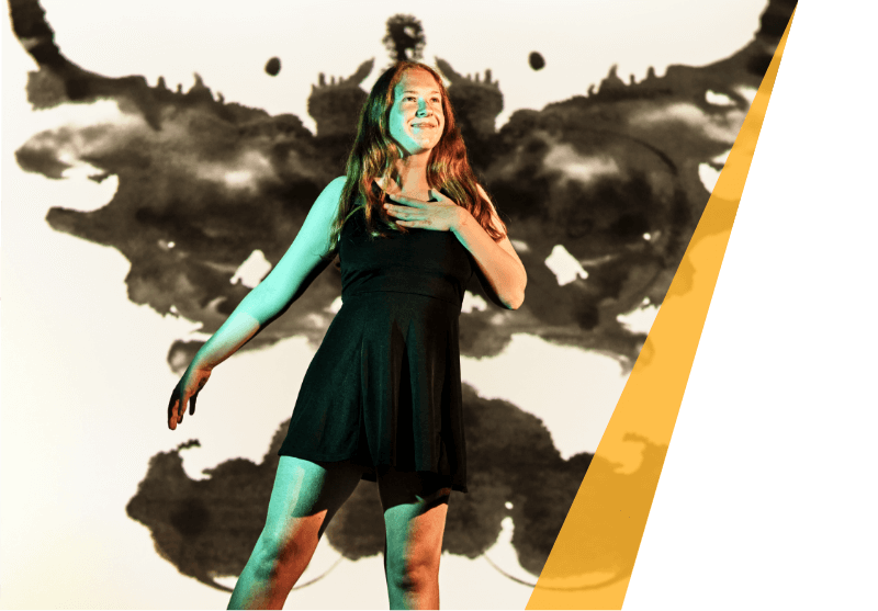 Serena Rush dancing in a black dress with a rorschach test graphic behind her 