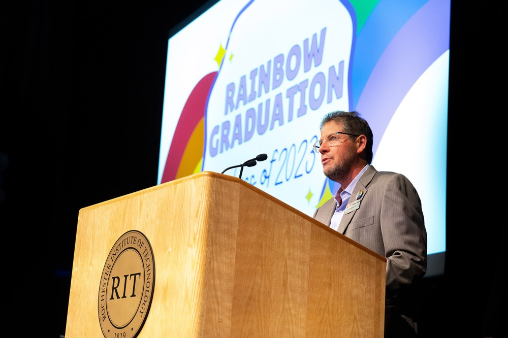 person speaking at a podium on a stage.