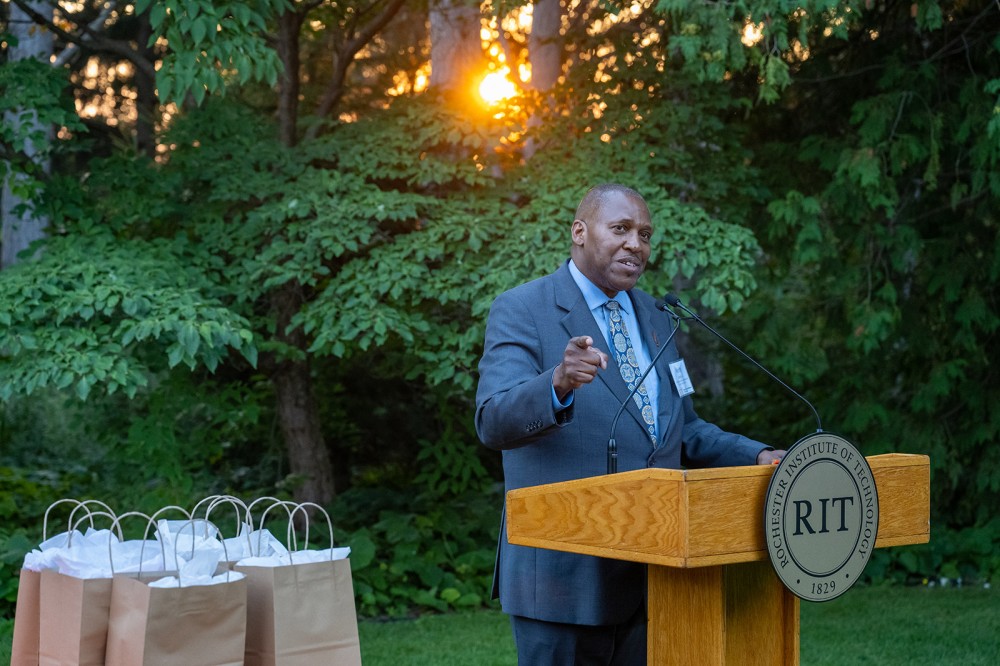 person speaking at a podium outdoors.