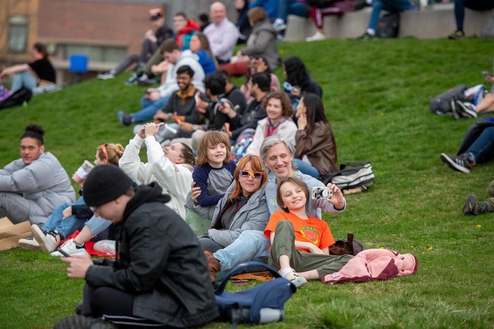 several students are shown gathered and sitting together waiting for the eclipse.
