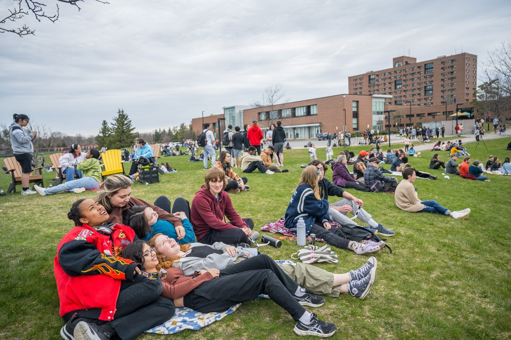 several students are shown gathered and sitting together waiting for the eclipse.