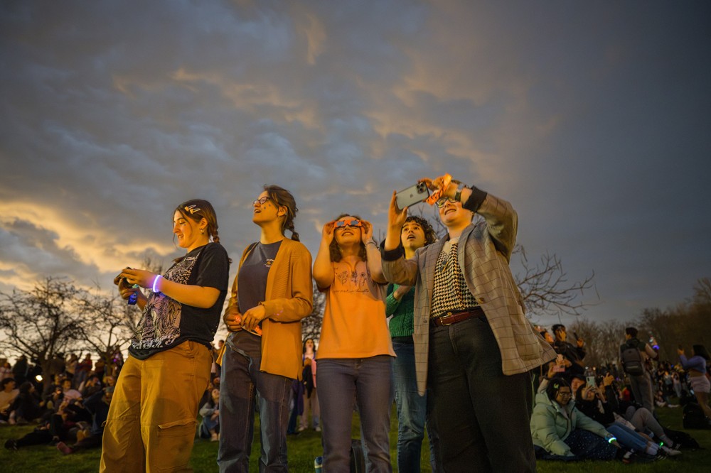 several students are shown gathered and standing together waiting for the eclipse.