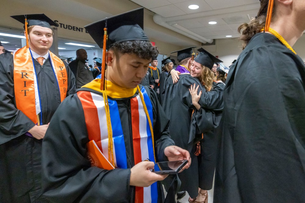 a student is shown in the background of the photo hugging a friend.