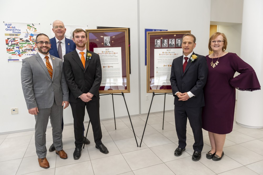 <p>Bobby Moakley, third from left, a fourth-year&nbsp;environmental science major and graduate student in science, technology and public policy, received the 2019 Bruce R. James Award, and James Myers, second from right, RIT’s&nbsp;associate provost for International Education and Global Programs, received the 2019 Four Presidents Distinguished Public Service Award during a ceremony on April 3. From left,&nbsp;James Macchiano, James Award selection committee chairperson; RIT President David Munson; Moakley; Myers; and Cindee Gray, Four Presidents Award selection committee chairperson.&nbsp;</p>

