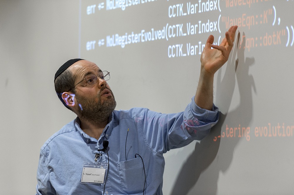<p>Yosef Zlochower, associate professor in the&nbsp;School of Mathematical Sciences, demonstrates&nbsp;code during one of the tutorial sessions at the 2019 North American Einstein Toolkit Workshop&nbsp;June 17.&nbsp;The Einstein Toolkit is a community-driven software platform of core computational tools to advance and support research in relativistic astrophysics and gravitational physics. The toolkit has a community of several hundred scientists working together to develop these tools, a set of codes to solve Einstein’s equations for binary black hole collisions, neutron star collisions and other astrophysical systems.</p>
