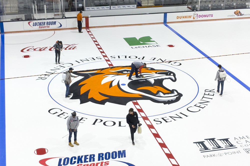 <p>The Gene Polisseni ice rink gets its yearly layers of ice and new logo to prepare for the fall season. A foundation layer of ice is painted white and then the RIT Tiger and other logos are applied. The final step is&nbsp;an additional layer of ice.</p>
