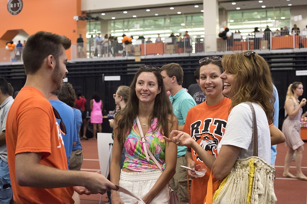 <p>Victoria Sears, center, a first-year interior design student from Rochester, N.Y., learns about RIT Dining&nbsp;options from Ben Levinson, a second-year&nbsp;graduate student in marketing. Her sister Rachel and mother Christine attended the Resource Fair with her to learn about RIT departments and their offerings.&nbsp;The New Student Orientation Resource Fair, held&nbsp;in the Gordon Field House August 20, provided information regarding resources and services at RIT and in the community.</p>
