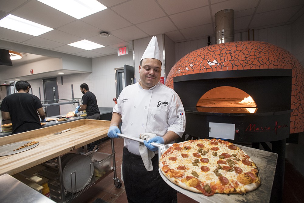 <p>Chef de Cuisine Daniel Morales created a pepperoni and sausage pizza&nbsp;at 700 degrees in 100 seconds in a&nbsp;new ceramic pizza oven, producing a crisp crust with a good char.&nbsp;Gracie's, RIT's largest dining facility, has reopened after a&nbsp;<a href="https://www.rit.edu/news/renovated-gracies-schedule-reopen-aug-12">$2 million renovation</a> of its kitchen and serving areas this summer.</p>
