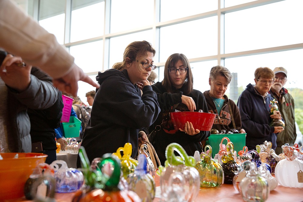 People shopping for glass pumpkins