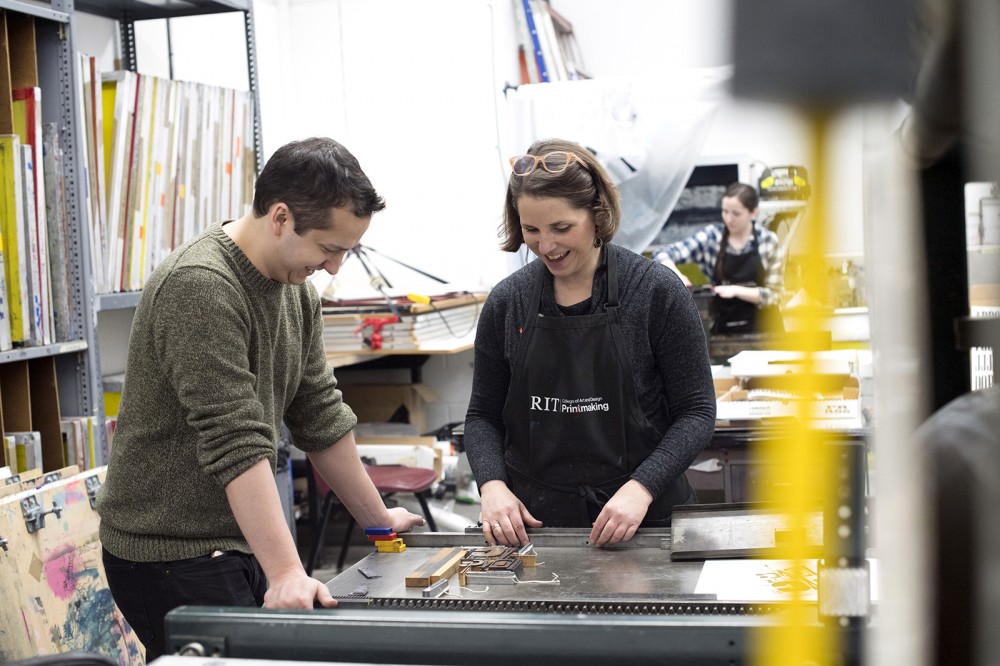 two people at printing press