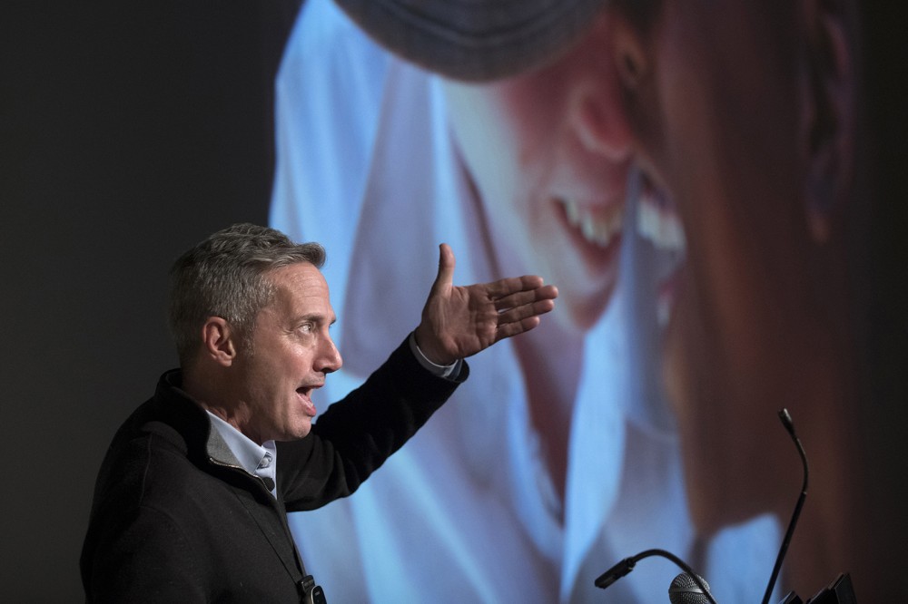speaker with image behind him