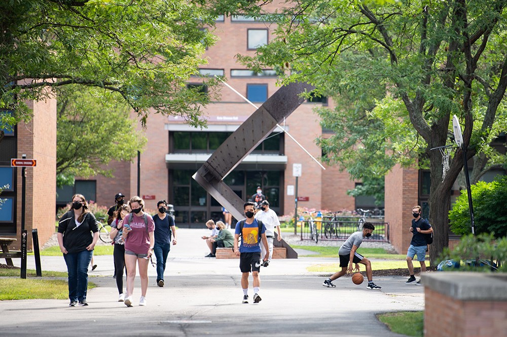 students wearing masks walking outside.