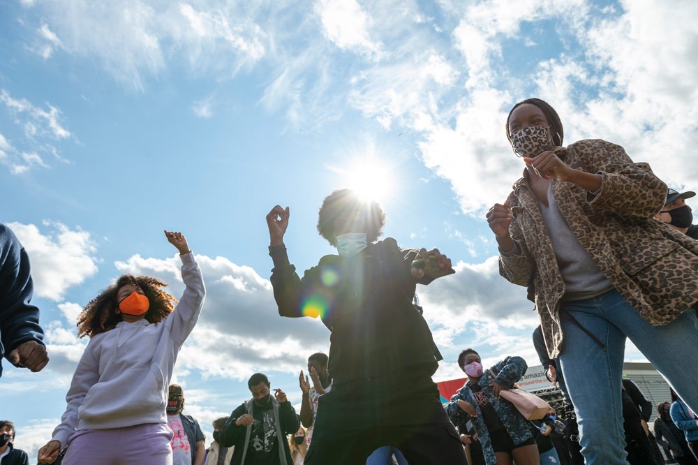 Students outdoors in lawn with blue skies and sunlight