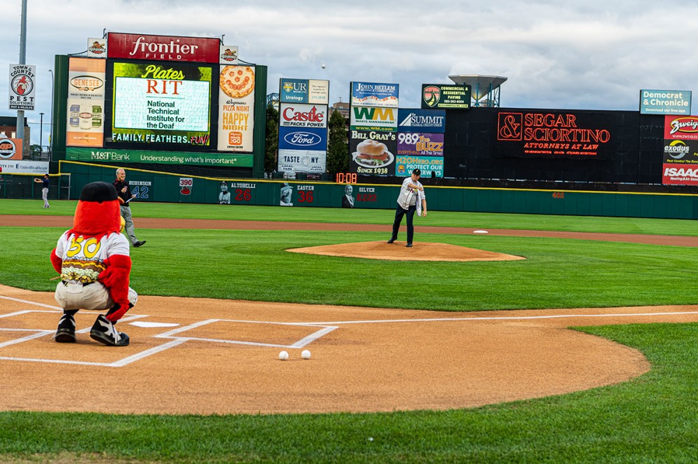 NTID president throwing pitch to Red Wings mascot.