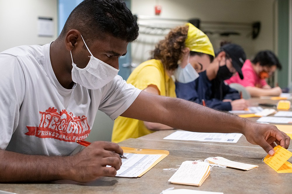 student filling out form for a medical examiner toe tag.