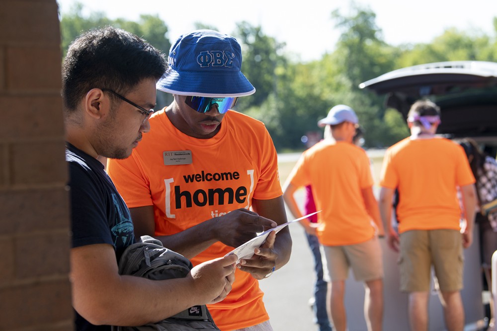 Orientation Leader Jay’llen Hathman helps an incoming student at move-in. More than 3,000 first-year students, from 49 states and 34 countries, are expected fall semester.
<br><p>Photo by A. Sue Weisler</p>