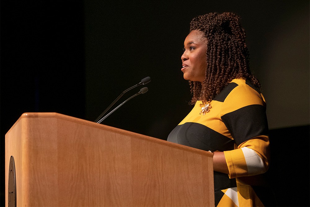 woman speaking at a podium.