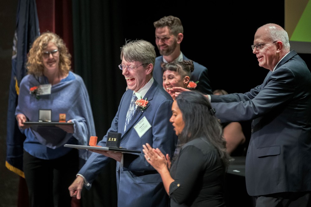 four award winners smiling and laughing.
