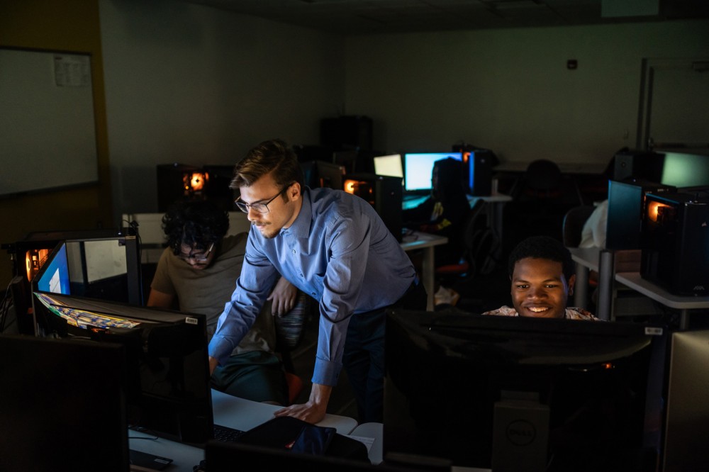 Omar Moralez-Saez, a third-year game design and development major, left, works alongside Shane Gayle, 17, of Rochester’s Vertus High School, during a game design camp at MAGIC Spell Studios. The camp, in partnership with RIT's K-12 University Center, taught the students the fundamentals of game design, programming logic, art, and animation through a combination of lessons and lab time. The students published their games at the culmination of the camp.
<br><p>Photo by Traci Westcott</p>