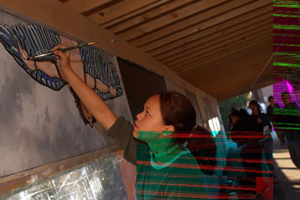 Sara Stryjewski, an RIT first-year graphic design student, paints a section of mural inside the 90-foot-long covered walkway built to ensure pedestrian safety along the quarter mile during construction of the Gordon Field House and Activities Center. The walkway, adorned with student art, was unveiled Oct. 10.

