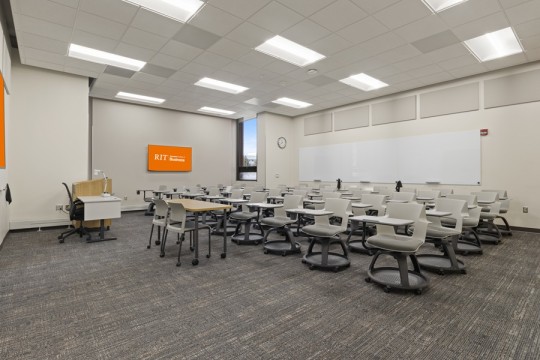 a large classroom space with individual desks and chairs. 