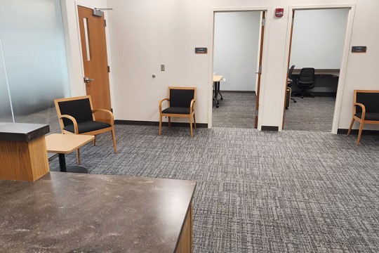 a reception area with seating and doors to other offices.