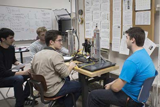 Student sitting around a desk with testing equipment