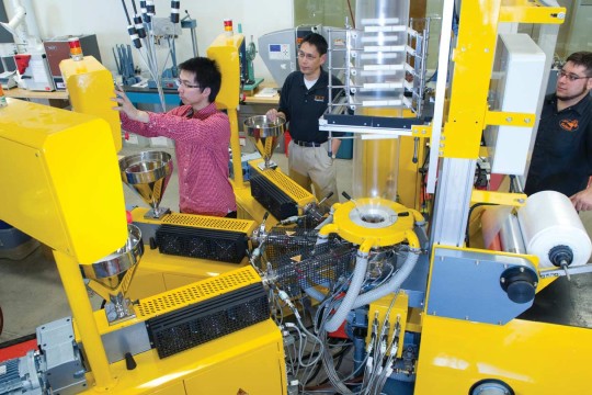 Three people calibrating a large machine