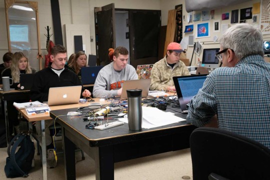 Students working on laptops in a small lab