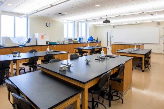Open lab with large desks and a projector