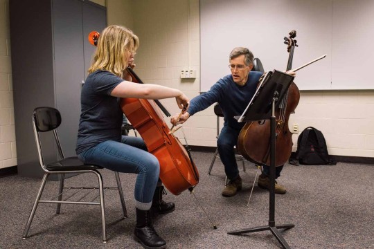 Male and female playing large string instraments