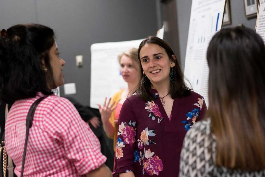 A student presenting her research poster.