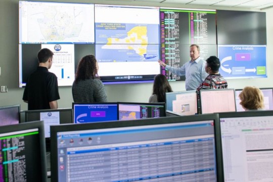 students and professor looking at crime data on large screens